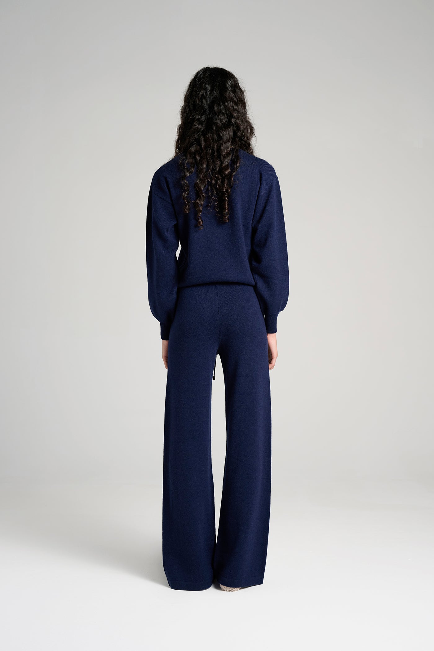 Model wearing Siena Pant Navy – stylish navy cashmere lounge pants for women, crafted in Italy for superior comfort, warmth, and timeless sophistication.