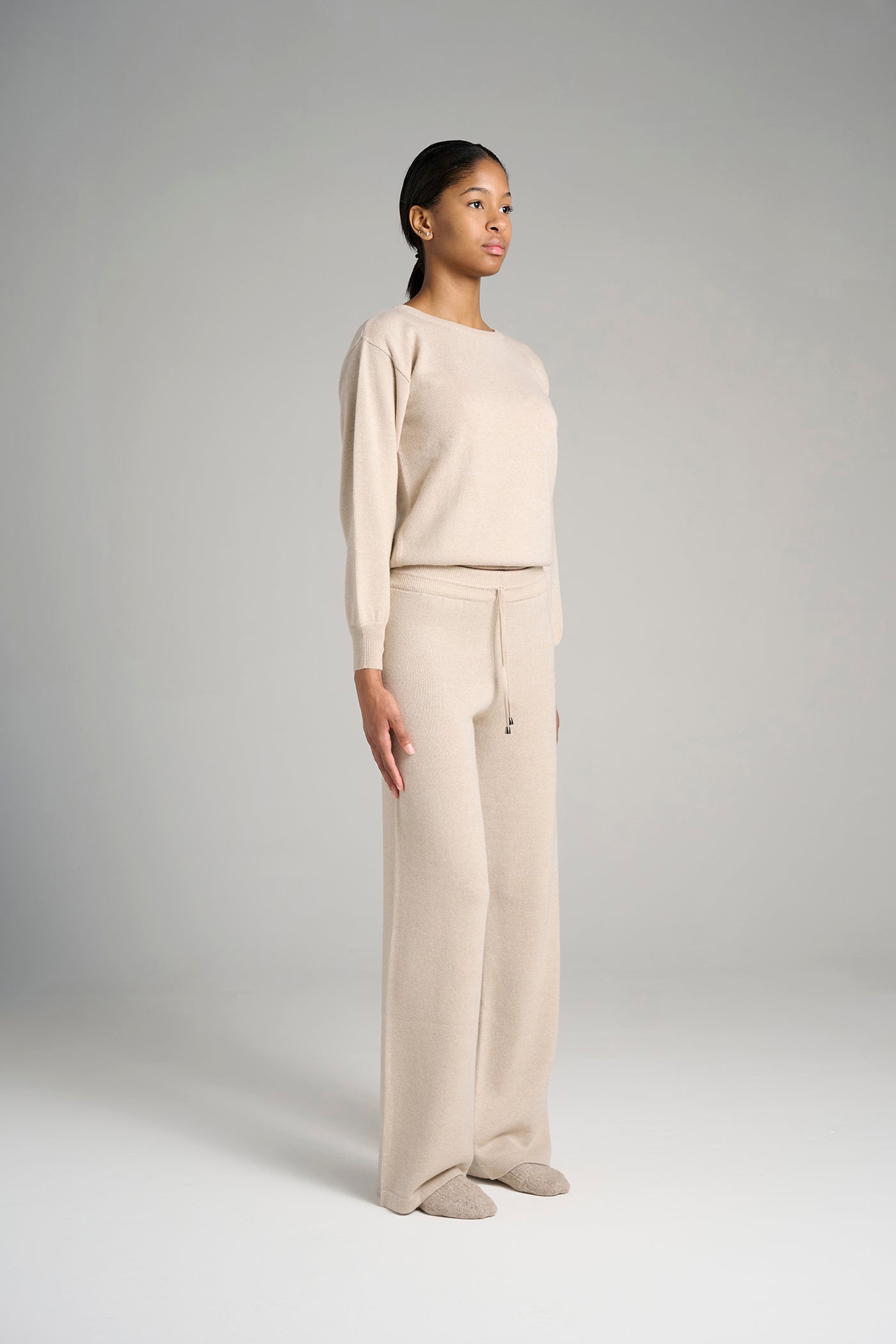 Model wearing The Verona Sweater in oatmeal. A neutral knit in 100% cashmere, made in Italy using Cariaggi yarn.