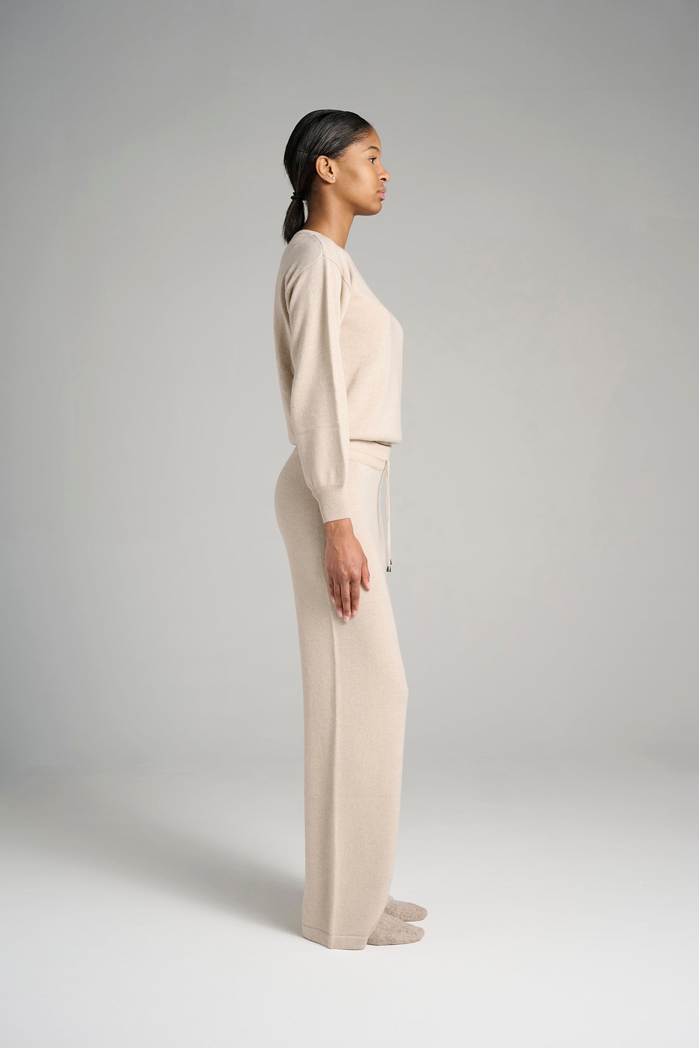 Model wearing Verona Sweater Oatmeal – classic cashmere sweater for women, crafted in Italy for superior warmth, softness, and timeless sophistication.