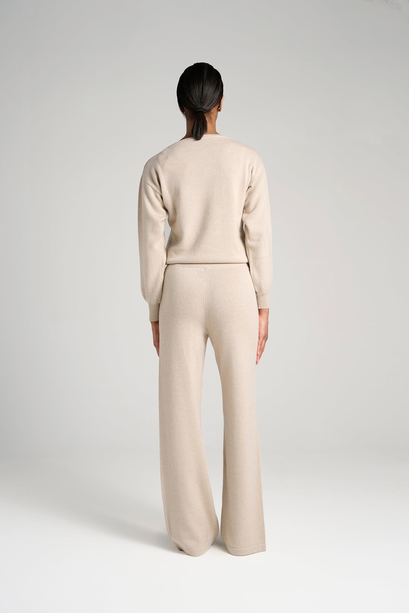 Model wearing Verona Sweater Oatmeal – classic cashmere sweater for women, crafted in Italy for superior warmth, softness, and timeless sophistication.
