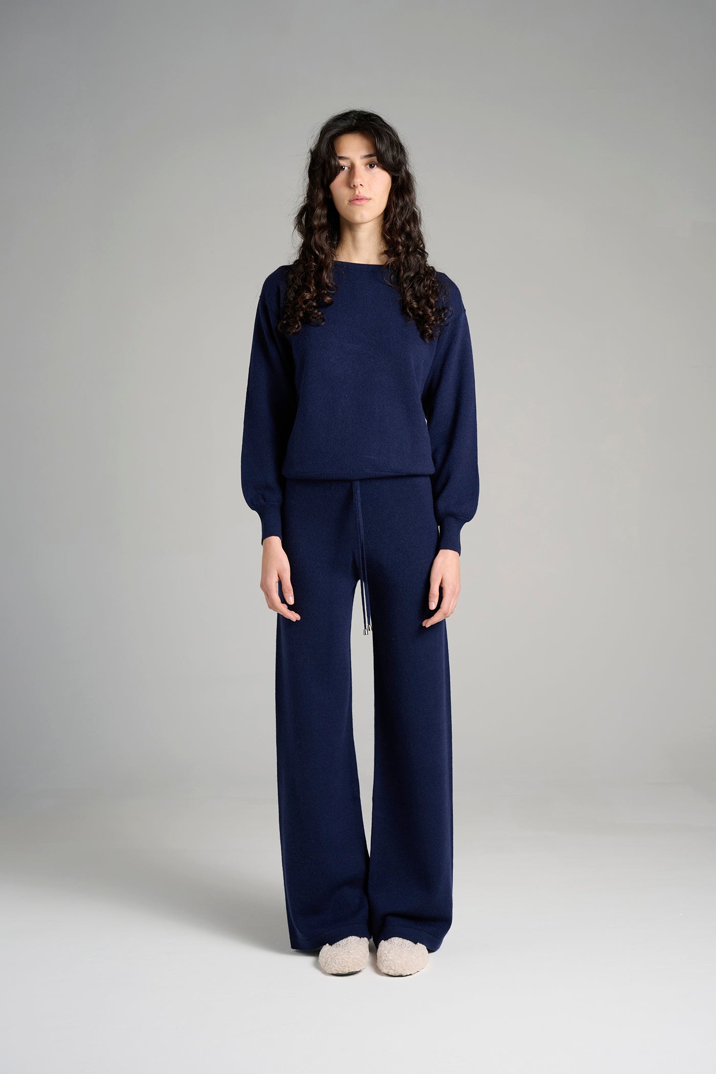 Model wearing The Verona Sweater in navy. Deep blue knit made in Italy from 100% Cariaggi cashmere.