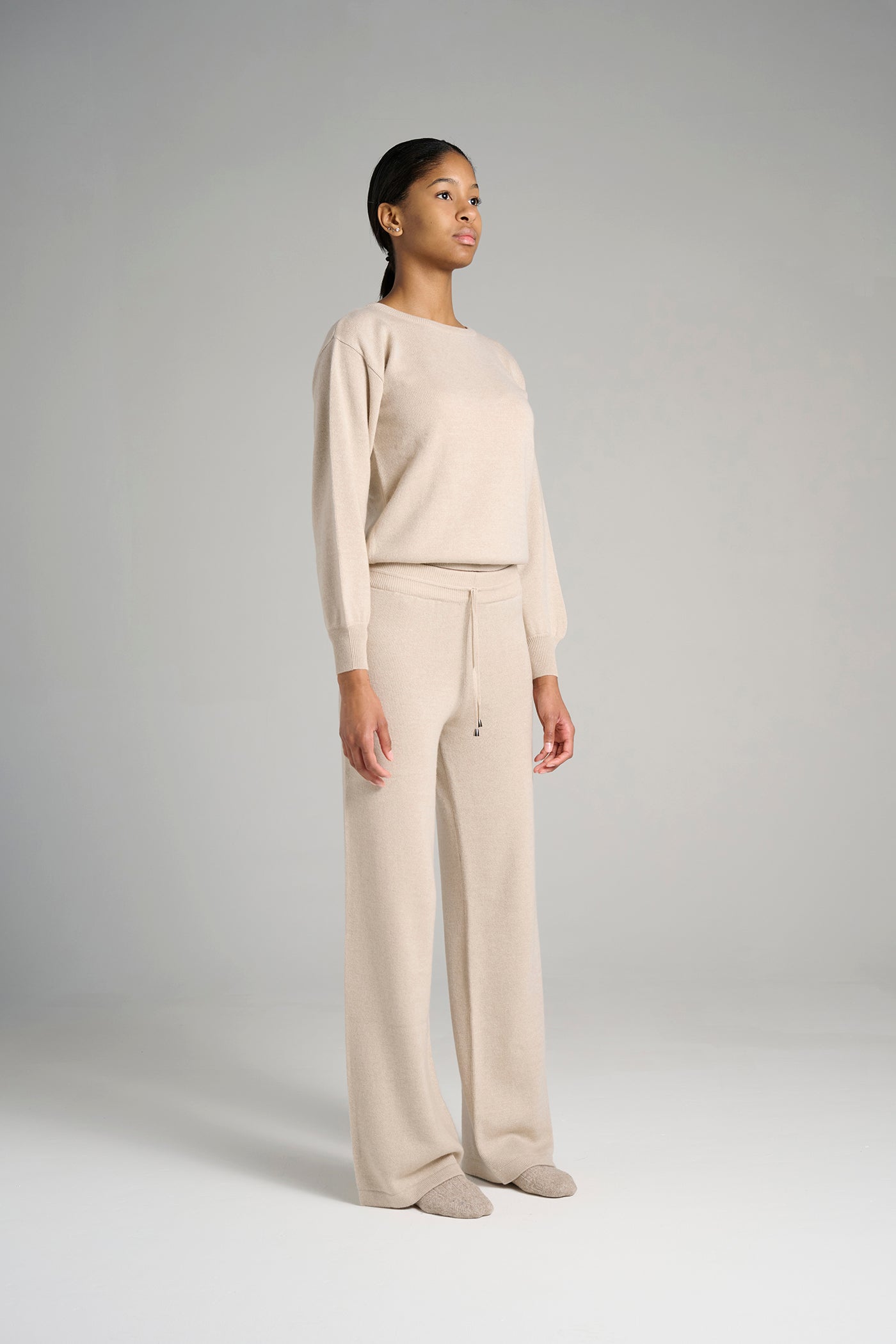 Model wearing The Siena Pant in oatmeal. Relaxed straight-leg shape in Italian-made Cariaggi cashmere.