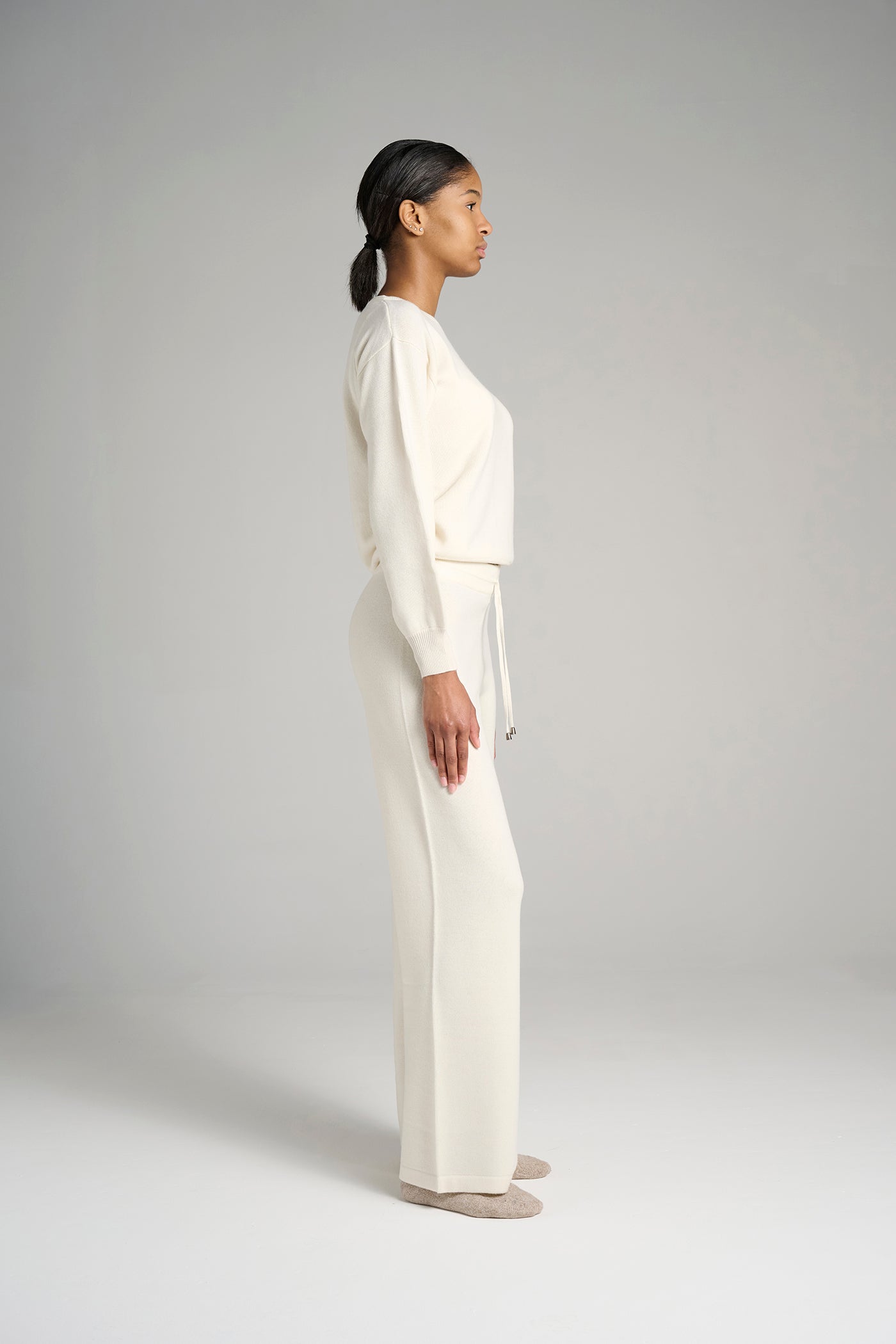 Model wearing Verona Sweater Snow – luxurious white cashmere sweater for women, crafted in Italy for ultimate softness, warmth, and sophisticated style.